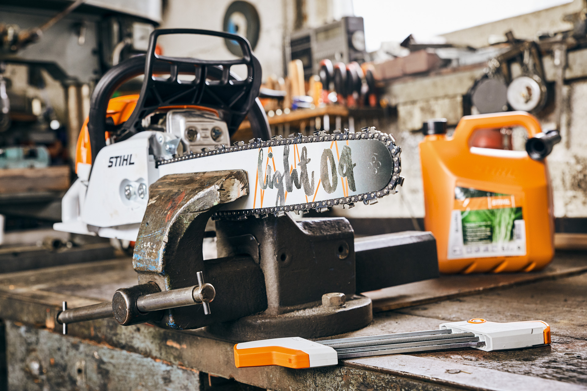 Motosharra me benzinë STIHL MS 261 C‑M me shinë udhëzuese Light 04, pranë përzierjes së karburantit STIHL MotoMix, përpara mprehjes