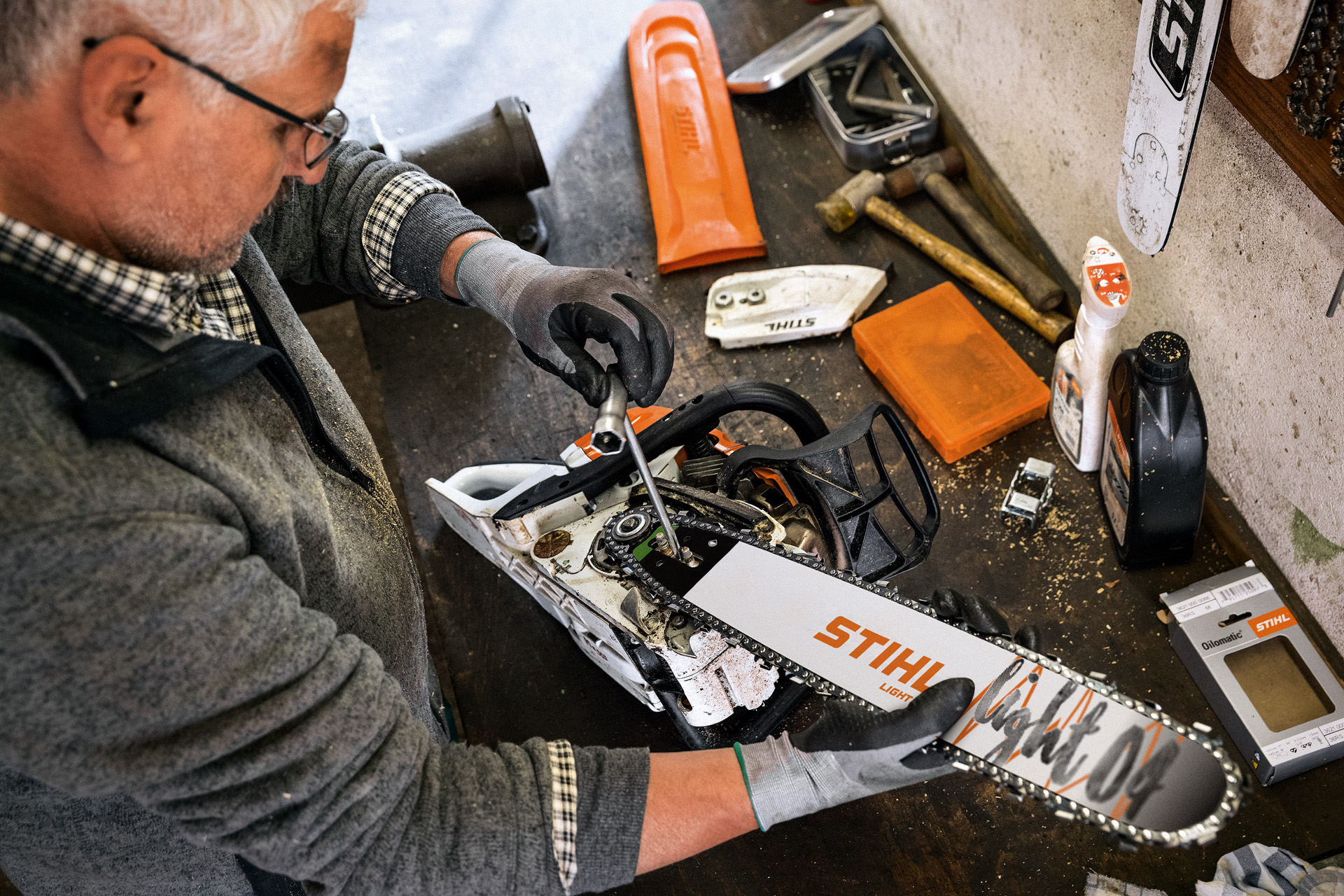 Një shitës STIHL kryen shërbime për një sharrë elektrike me zinxhir që ka një shufër udhëzuese STIHL Light 04 dhe zinxhir sharre Oilomatic.