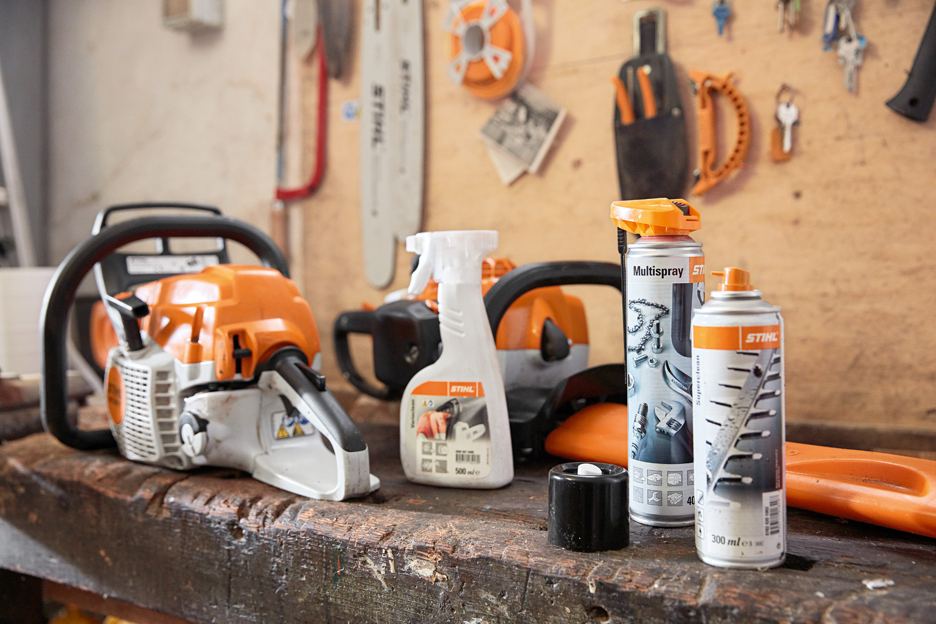 Një tavolinë pune me disa produkte STIHL mbi të: një motosharrë, Varioclean, Multispray dhe tretës rrëshire Superclean.