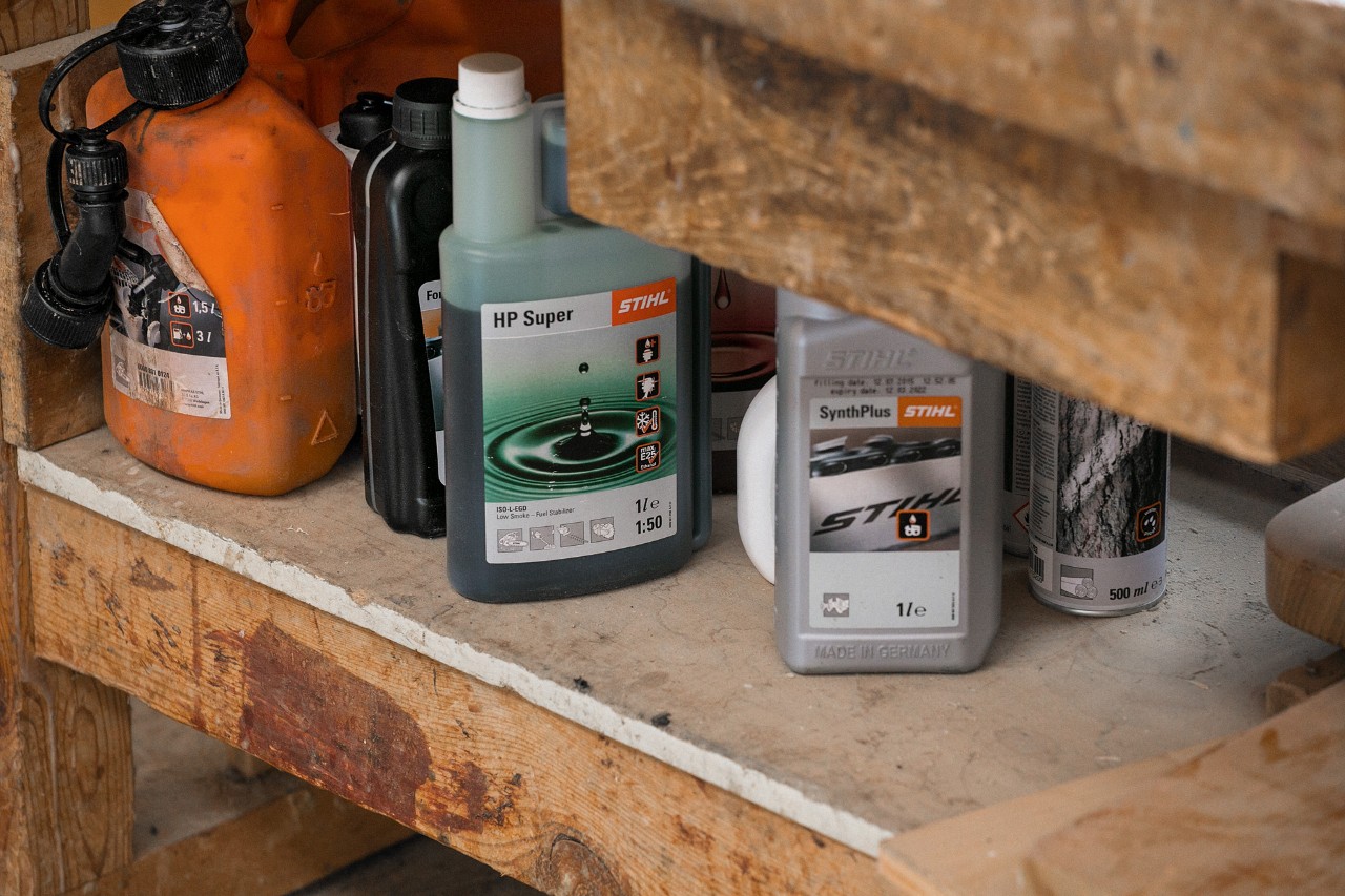 Vaj zinxhiri STIHL SynthPlus dhe vaj motori me dy kohë STIHL HP Super pranë karburanteve të tjera në një raft