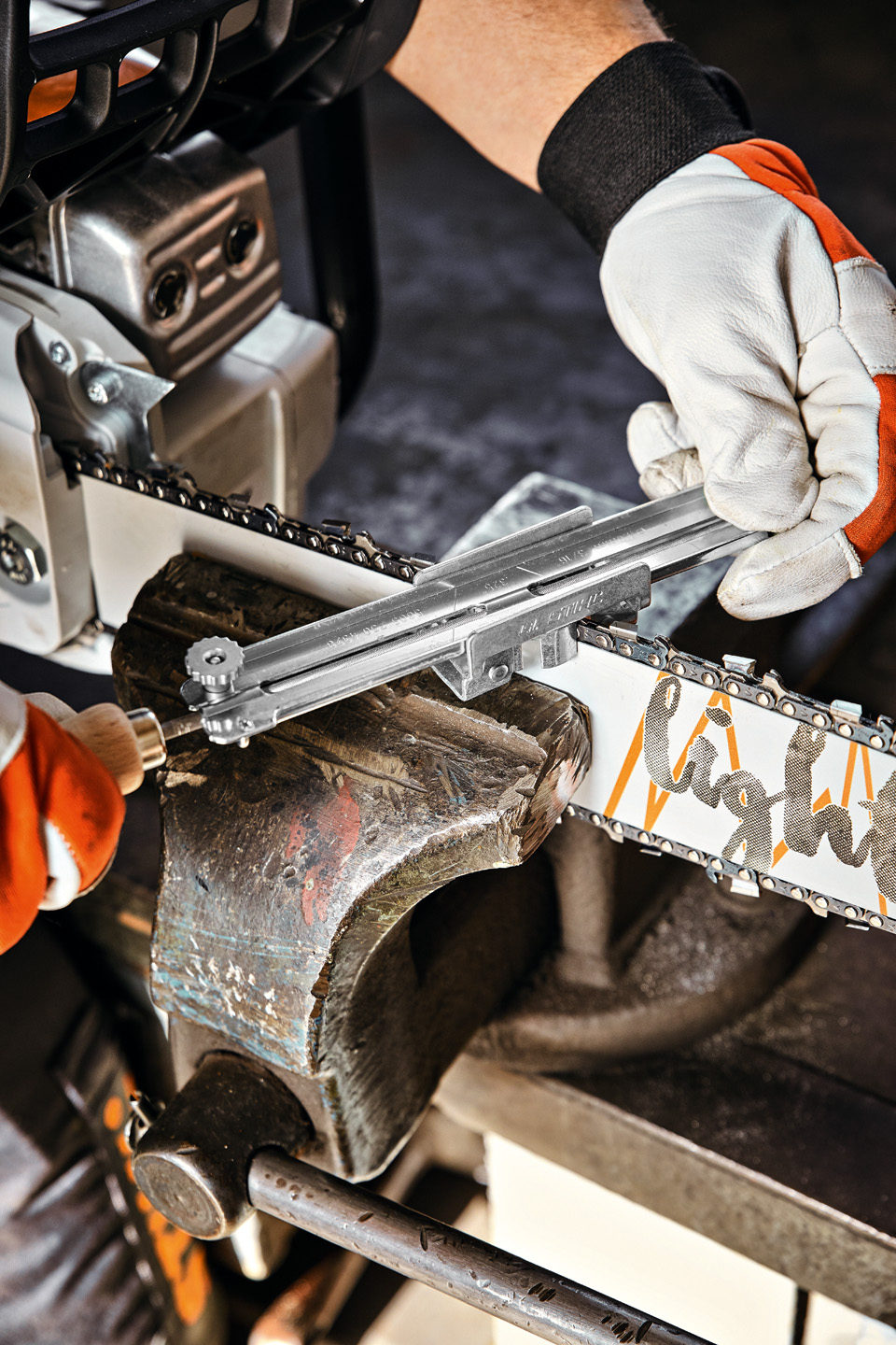 Një person me mbajtësin udhëzues të limës STIHL mbi një shinë udhëzuese STIHL Light 04.